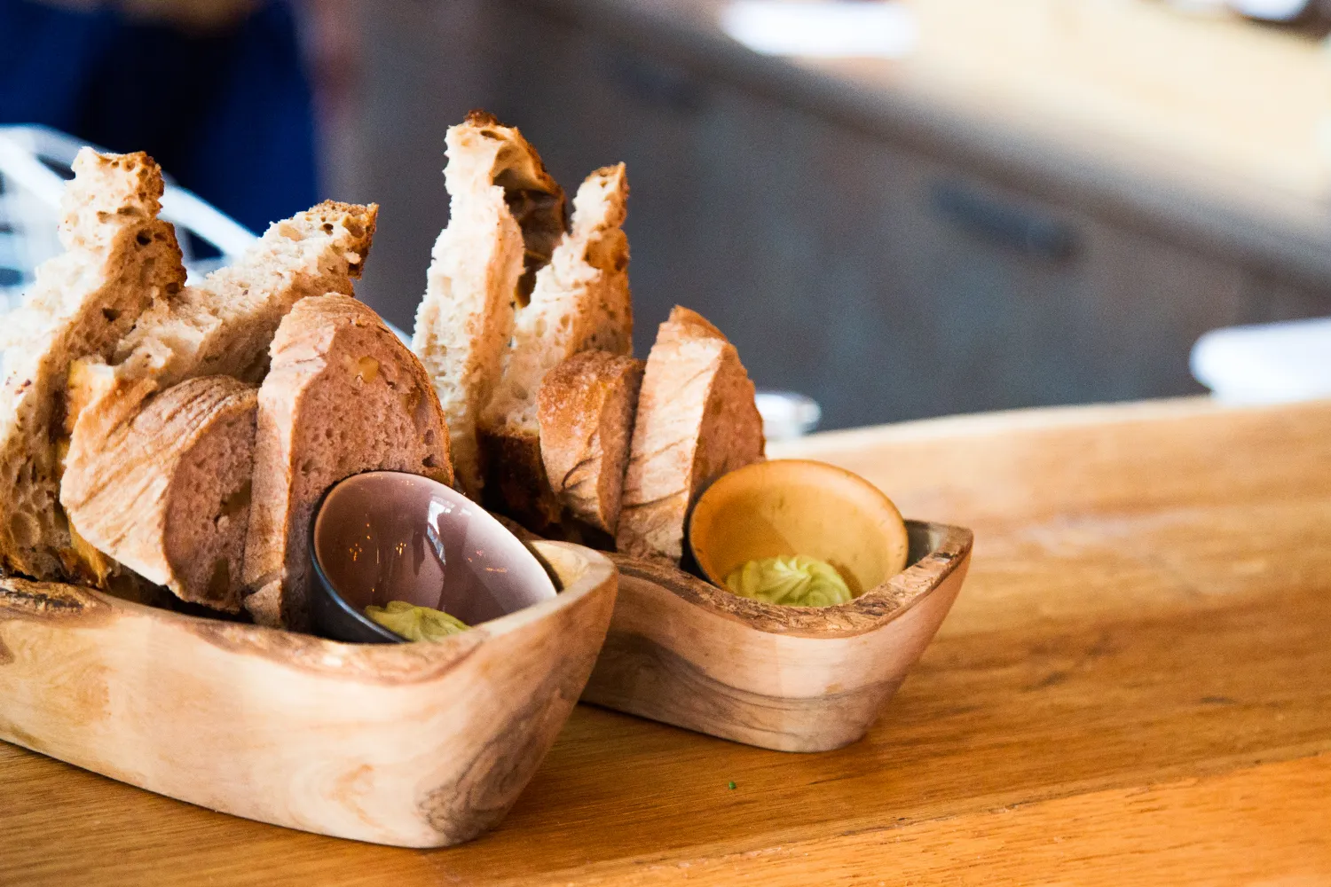 Frisch gebackenes Brot im Holzkorb mit Aufstrichen