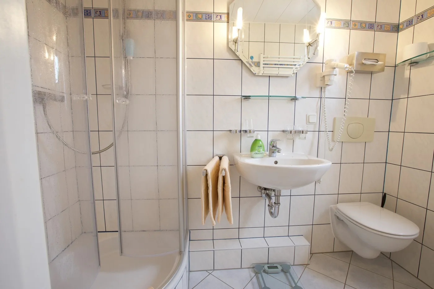 Bad im Dreibettzimmer mit Dusche, Waschbecken und WC